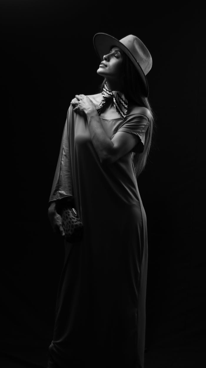 services-03 Black and white portrait of a stylish woman in a hat with dramatic lighting.